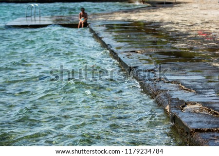 The typical picture from the Croatian coast showing the detail of the concrete beach with direct access to the sea. 