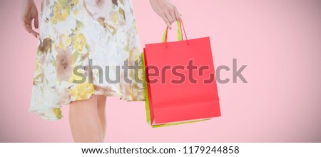 Elegant woman with shopping bags against pink background 