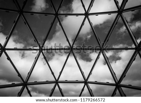 A black and white triangle and polygon design windows with sky and white clouds in the background.