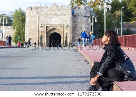 Chinese Girl Sitting on the Bridge and Enjoying Sunny Day