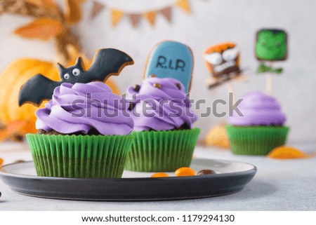 Festive Halloween treats: colorful cupcakes, gingerbread cookies and sweet marshmallow monsters. Selective focus.