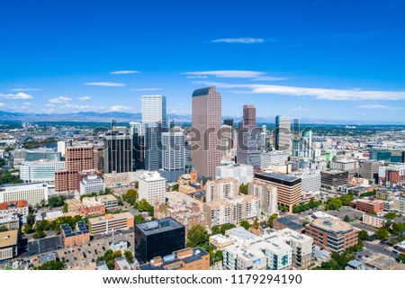 The pinnacle shot of Denver Colorado Skyline Cityscape Aerial drone view with Rocky Mountain background stretching across horizon and vast growing city surrounding rising downtown towers