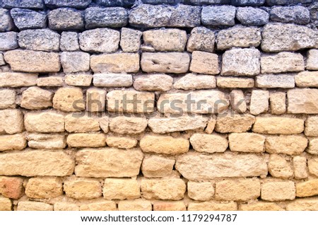 An old ancient yellow stone wall. Abstract background texture. Macro.