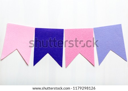 Handmade decor flags of felt, garland blank, flat buntings garlands, flags, celebration decor. Template for text on a white wooden background