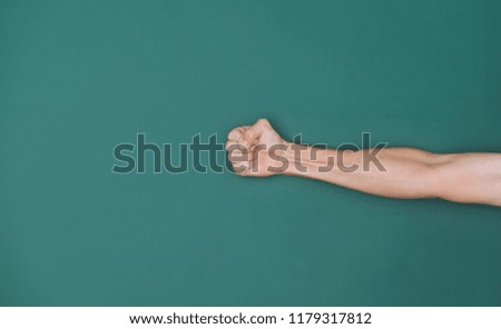 Man fist in front of chalkboard.