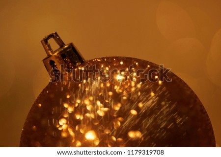 close up of golden glittering christmas ball for decoration isolated on brown