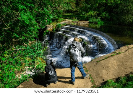 Landscape Photographers & tourists taking pictures of a waterfall in the Peak District National Park, Bakewell