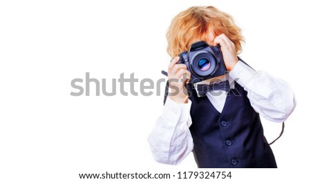 
little photographer, boy with camera, stylishly dressed child in a waistcoat with a tie takes pictures on a digital camera