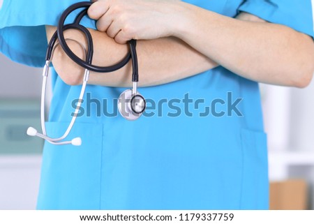 Doctor holding stethoscope with arms crossed, closeup. Medical help and insurance in health care, best treatment and medicine concept