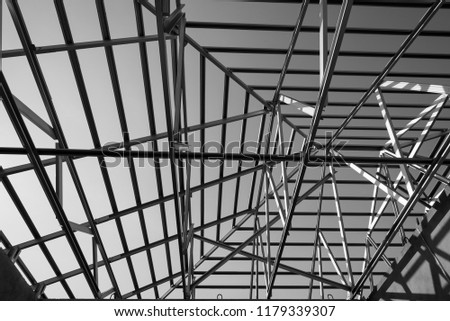Structure of steel roof frame for building construction. Black and white photo.