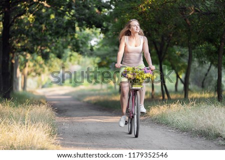 
Beautiful sports girl on a retro bike in the park for a walk.