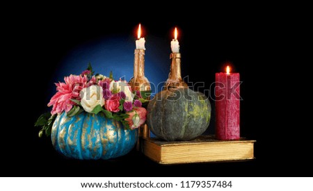 Halloween composition of decorated pumpkins and candles on black background
