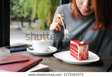 Asian women using a stainless spoon to eat a red velvet cake,Relax time with enjoy eating sweet