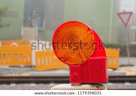 close-up of yellow warning lamp at construction site at misty morning