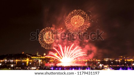 Orange and red fireworks in front of Quebec City during a summer festival.