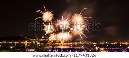 Bright detailed fireworks in front of Quebec City during a summer festival.