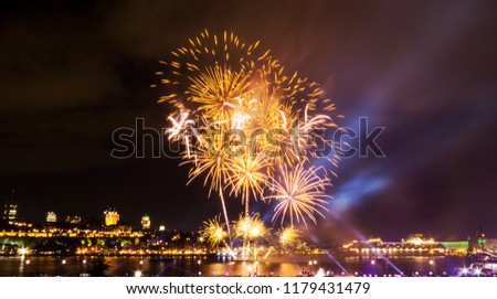 Orange/Gold fireworks over the Saint-Lawrence River near Quebec City during a Canadian summer festival.
