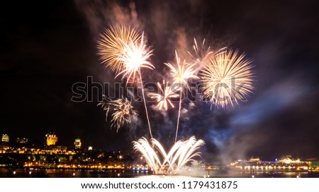 Intense fireworks in front of Quebec City during a summer festival.