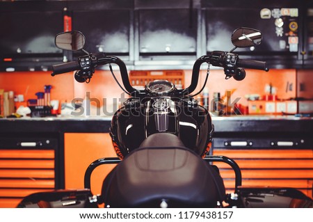 motorcycles on the floor with workshop tools, a modern garage, storage and repair. This bike will be perfect. repairing a motorcycle in a repair shop. Royalty-Free Stock Photo #1179438157