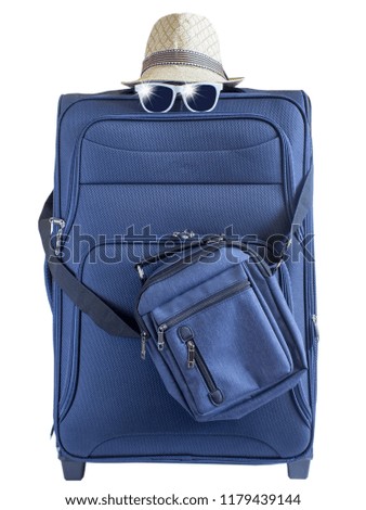 Blue suitcase with a summer hat and fashionable glasses on light white background. Travel background.