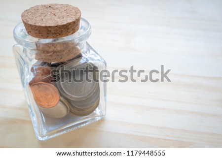 Savings concept. coins in bottle on wooden background and copy space used for add messages.