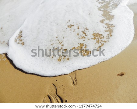 Picture taken of waves at Bournemouth beach. Footprints leading into the water.