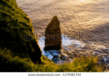 Looking down at a rock at the cliffs of moher during sunset and 