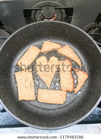 Rye bread is fried in a frying pan in oil, croutons, suhariki in the form of heart.