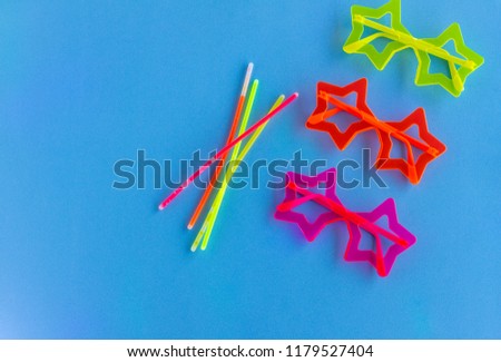 Neon Party supplies on  blue background - Photo booth Props. Copy Space.  Party background