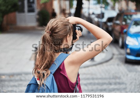 A young girl photographs old buildings. Tourist girl takes photos of the old town. Batumi.