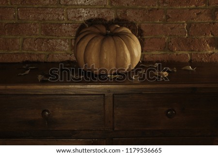 Portrait of a pumpkin on an antique piece of furniture in a dark night. Concept: Halloween, horror, scary