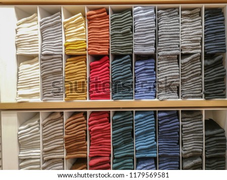 Cotton T-shirt folded neatly in the showroom,Colorful clothes folded in the cabinet,Colorful clothes neatly dressed,Shelves and multi-colored clothes in large stores,A row of colorful shirts. Royalty-Free Stock Photo #1179569581