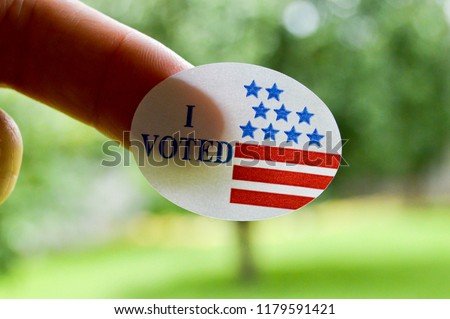I voted sticker on a woman’s finger