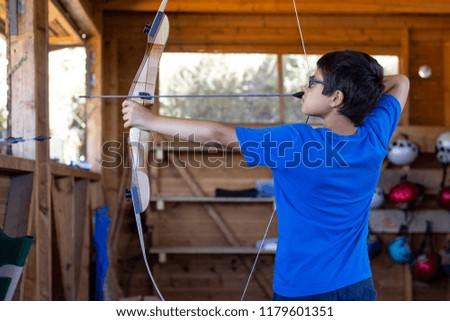 boy practicing archery Royalty-Free Stock Photo #1179601351