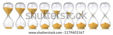Collection of hourglasses with yellow sand showing the passage of time Royalty-Free Stock Photo #1179601567