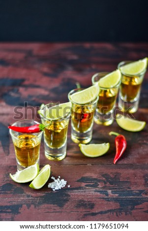  five glasses of alcohol and lime and red chili, a party at the bar, a menu for the bar. Tequila shots, vodka,whisky, rum. Selective focus and copy space