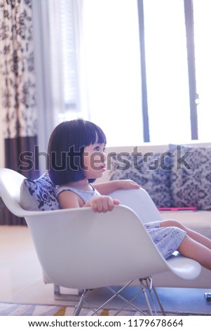 Close up picture of girl seating on rocking chair while watching television 