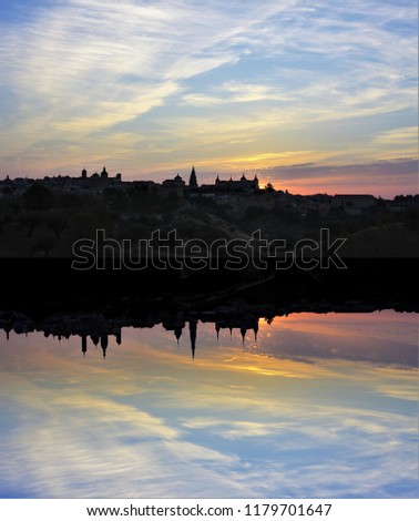skyline of the city of Toledo reflected in the water of river during the sunrise, seen from the cigarrales, Castilla La Mancha, Spain, sunrise in the city of Toledo, Spain, reflected in the water,