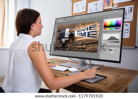 Female Designer Editing Image In Computer Using Graphic Tablet