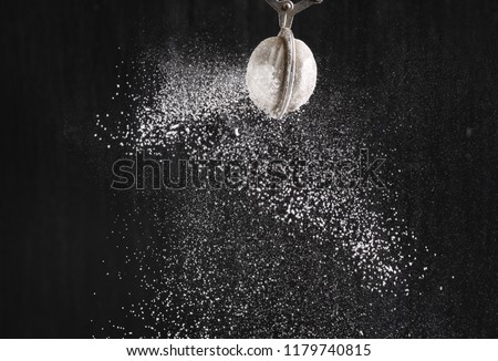 fluffy powdered sugar on black background