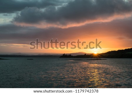 This is a picture of  Lough Swilly Donegal Ireland at Sunset.  In the distance there is the silhouette of Inch Castle.