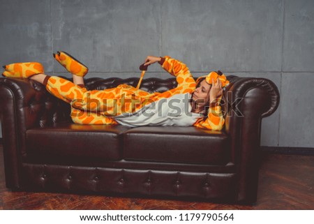 Pajamas for Halloween in the form of a kangaroo. Emotional portrait of a girl on a sofa background. Crazy and funny man in a suit. Clean skin and long hair. Animator for children's parties
