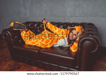 Pajamas for Halloween in the form of a kangaroo. Emotional portrait of a girl on a sofa background. Crazy and funny man in a suit. Clean skin and long hair. Animator for children's parties

