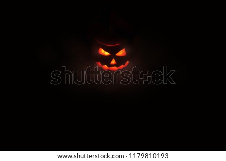 Halloween concept, glowing red outline of Jack's lantern from the carved pumpkin from which the light comes. the center of the frame, isolate on black background