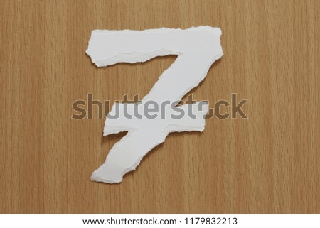 number 7 made of recycled torn paper craft on wood background