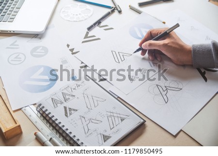 Graphic designer drawing sketch design creative Ideas draft Logo product trademark label brand artwork. Graphic designer studio Concept.