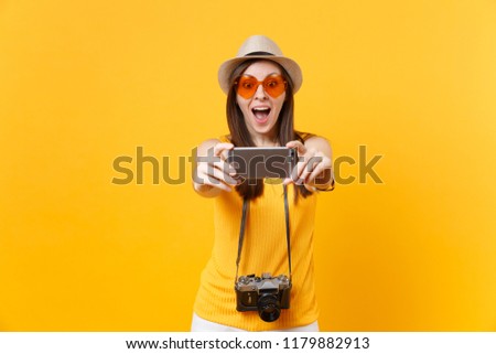 Tourist woman in summer casual clothes, hat doing taking selfie shot on mobile phone isolated on yellow background. Female passenger traveling abroad to travel on weekends getaway. Air flight concept