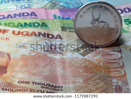 Uganda banknotes with coins, background