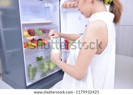Pregnant girl find something to eat in refrigerator. And she found a bottle of milk. In the refrigerator have a lot vegetables and fruits. It's have a lot nutrient important for fetus too much.
