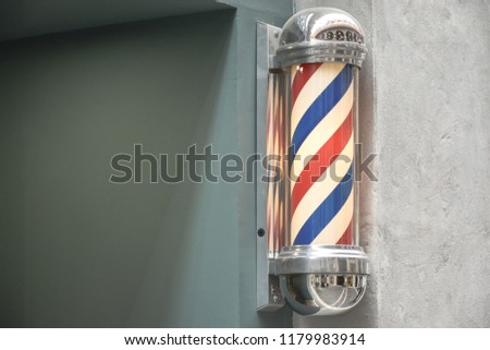 Close up to barbershop pole on wall background view. Copy space.